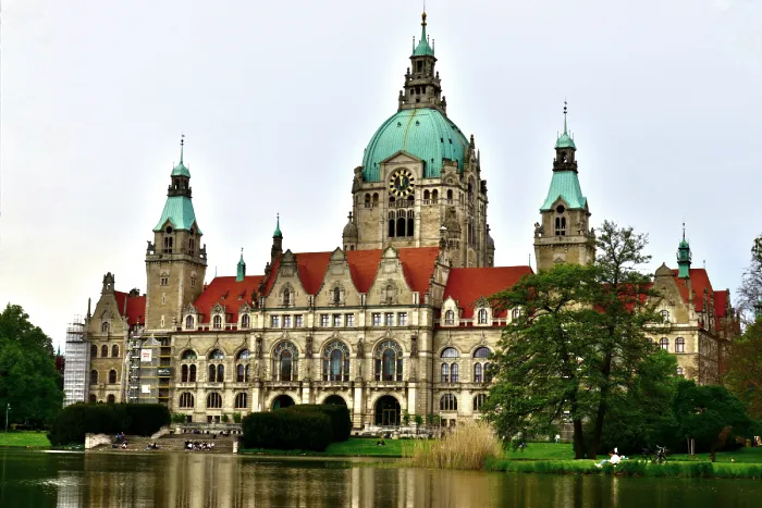 Blick auf das Neue Rathaus in Hannover mit Teich und Park im Vordergrund, regionales Wahrzeichen in der Nähe der Projekte von DWD Solartechnik.